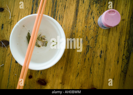 Fish bones on table next to bowl with chopsticks Stock Photo