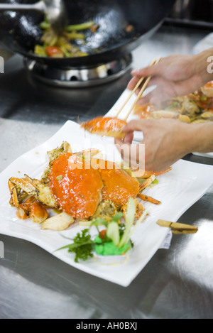 Chef dressing plates in commercial kitchen