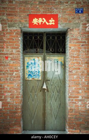 Closed doors with posters on door and banner overhead, China Stock Photo