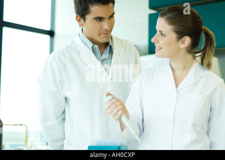 Young female lab worker smiling at supervisor Stock Photo