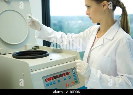 Young female researcher using centrifuge Stock Photo