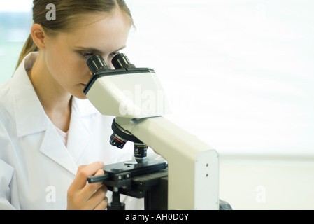Young woman using microscope Stock Photo