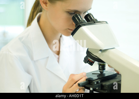 Young female scientist using microscope Stock Photo
