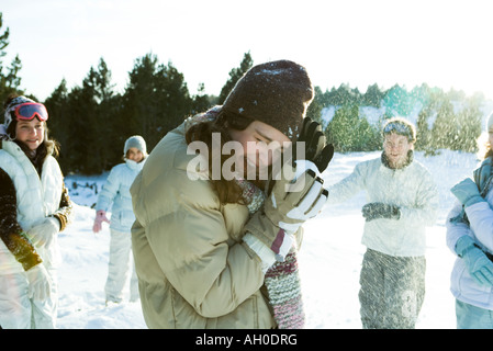 Young friends throwing snowballs, smiling, blurred motion Stock Photo