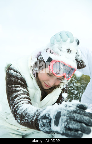 Teenage girl in snowball fight, bending over Stock Photo