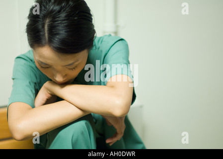 Woman resting head on arms, head down, close-up Stock Photo