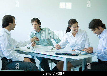 Business associates seated at table, chatting, three quarter length Stock Photo
