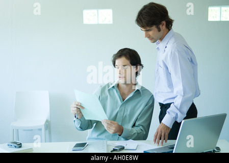 Two businessmen in office, looking at document Stock Photo