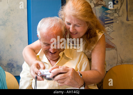 Elderly couple looking at photos on a digital camera, England UK Stock Photo