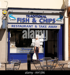 Man with Take Away Outside Fish Chip Shop Reading Notices in Window in Sutton Surrey England Stock Photo