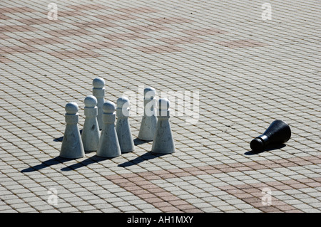 Eight pawns in a game, the black one is fallen over the white ones are still standing Stock Photo