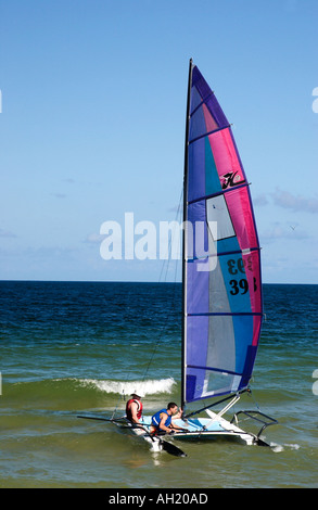 Two Caucasian men in bathing suits enjoy a sailboat ride on a sunny day in Fort Lauderdale, Florida, USA. Stock Photo
