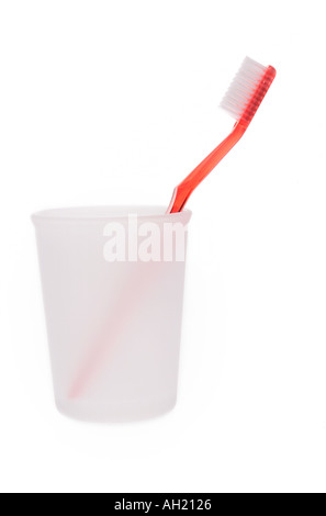 A single toothbrush in frosted plastic cup silhouetted on white background Stock Photo