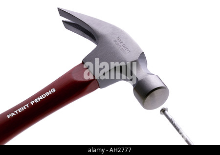 hammer striking a nail silhouetted on white background Stock Photo