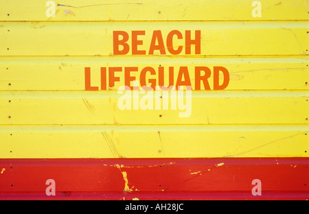 Detail of the side of a Lifeguard hut in the yellow and red of Lifeguarding colours with the words Beach Lifeguard Stock Photo