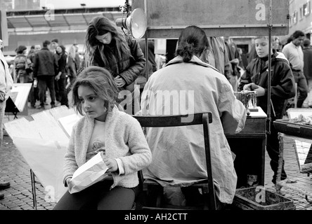 Street scene in Rome Italy Black and white Girl sitting waiting for mother to finish painting Piazza Navona Rome Italy Stock Photo