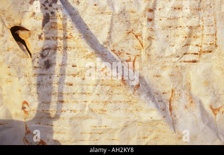 Detail of white tarpaulin sheet with abstract rust stains a tear and ripples and shadows Stock Photo