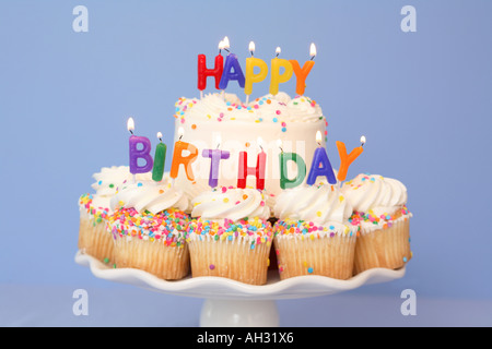 Cake and Cupcakes with HAPPY BIRTHDAY Candles Stock Photo