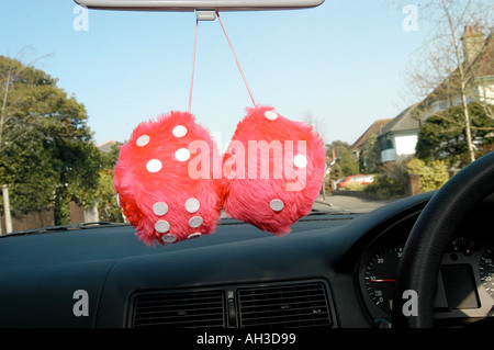 pink fury dice hanging in car window Stock Photo