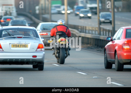 motorcycle cutting through traffic in london  uk Stock Photo