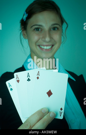 Portrait of a young woman holding playing cards and smiling Stock Photo