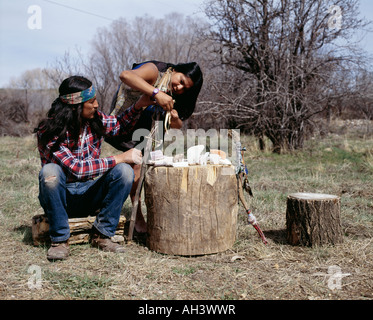 Native American Bear Carvers working on wooden logs in forest Stock Photo