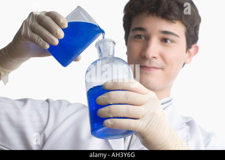 Close-up of a scientist pouring liquid into a flask Stock Photo