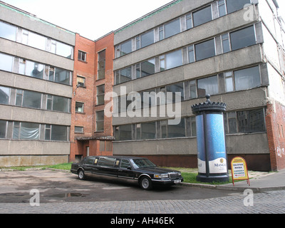 sedan car in front of abandoned socialist element building in centre of town Riga Latvia Stock Photo