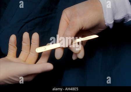 hands passing scalpel 1825 Stock Photo