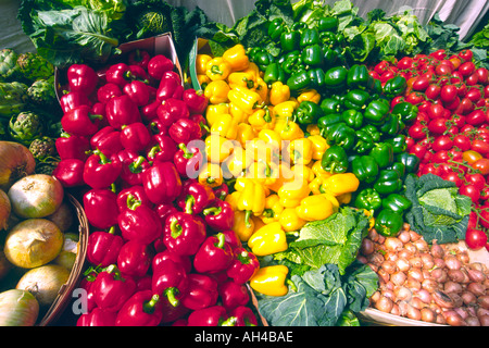 Assorted vegetables including onions, tomatoes, cabbage and red, green and yellow peppers at a market stall. Stock Photo