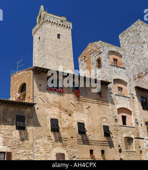 Ancient Torri degli Ardinghelli twin towers in Piazza della Cisterna Palace castle in San Gimignano Tuscany Italy with blue sky Stock Photo