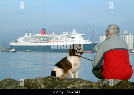 Queen Mary 2 on Southampton Water Man and  His Dog Called Skipper a Springer Spaniel Watching Waiting England UK Stock Photo