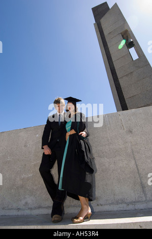 Woman in mortar board and gown with boyfriend on Graduation day, Arts Centre piazza, Aberystwyth University Wales Stock Photo