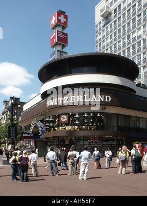 Street scene archival historical view of The Swiss Centre & people watching revolving clock display & Glockenspiel Leicester Square West End London UK Stock Photo