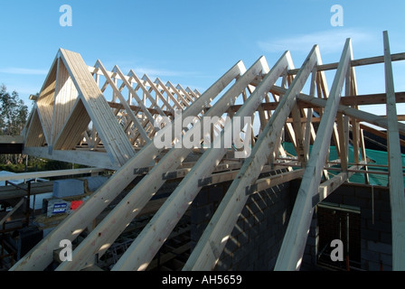Detached house work in progress fixing prefabricated roof trusses in position Stock Photo