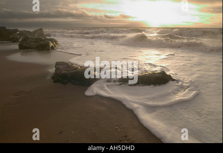 Surf breaking on rocks on Ness Beach at sunrise Shaldon Devon Great Britain Stock Photo