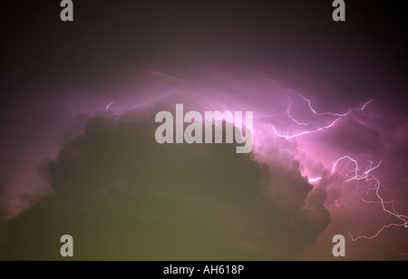 Multiple cloud to cloud lightning strikes from a growing thunderstorm near Lubbock, Texas. The clouds show some of the effects of light pollution Stock Photo