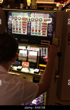 Playing on the one armed bandits in a casino in Las Vegas Stock Photo