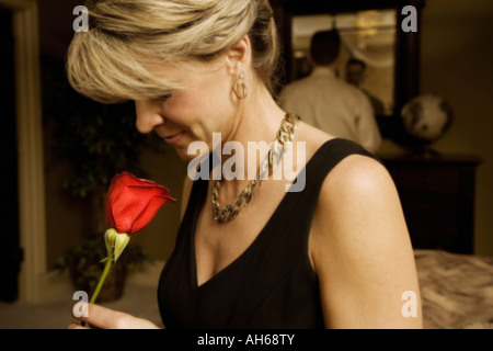 Woman smelling a red rose Stock Photo