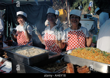 Women cooking and selling oriental food at  street festival. Stock Photo