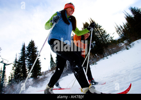 Low angle view of a young woman and a mid adult man skiing Stock Photo
