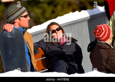 Young woman sitting on a bench wearing sunglasses Stock Photo