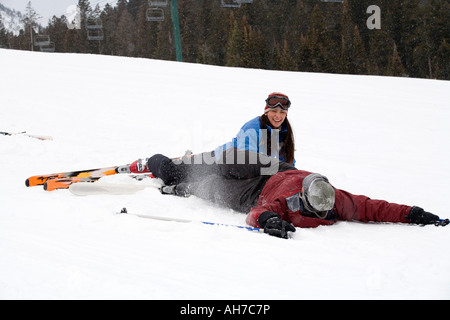 Young woman and a mid adult man fallen on the snow Stock Photo