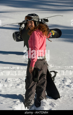 Rear view of a young woman carrying a snowboard Stock Photo