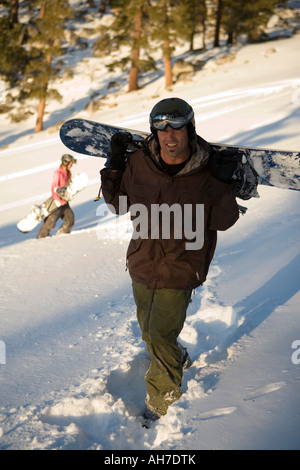 Mid adult man carrying a snowboard Stock Photo