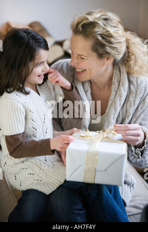 Mid adult woman and her daughter opening a Christmas present Stock Photo