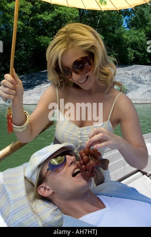http://l450v.alamy.com/450v/ah7htj/young-woman-sitting-in-a-boat-feeding-grapes-to-a-young-man-resting-ah7htj.jpg