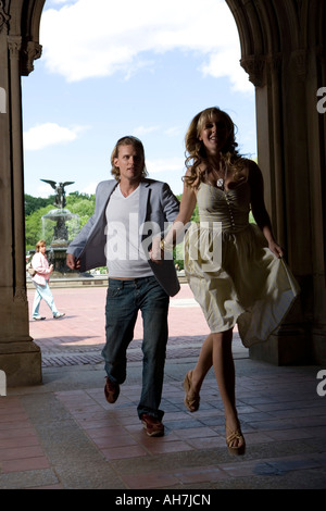 Young couple running through an archway and smiling, Central Park, Manhattan, New York City, New York, USA Stock Photo