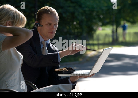 Businessman pointing with a chopstick at a laptop Stock Photo