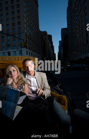 Young couple riding in a horsedrawn carriage and holding a road map, Central Park, Manhattan, New York City, New York, USA Stock Photo